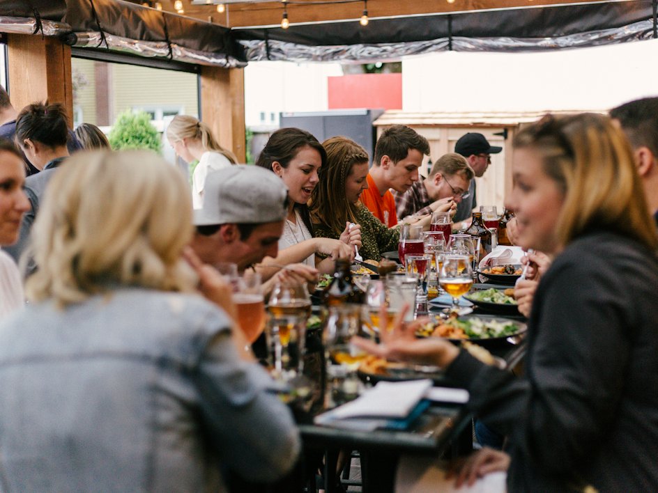 A community of friends sharing a meal around a long table