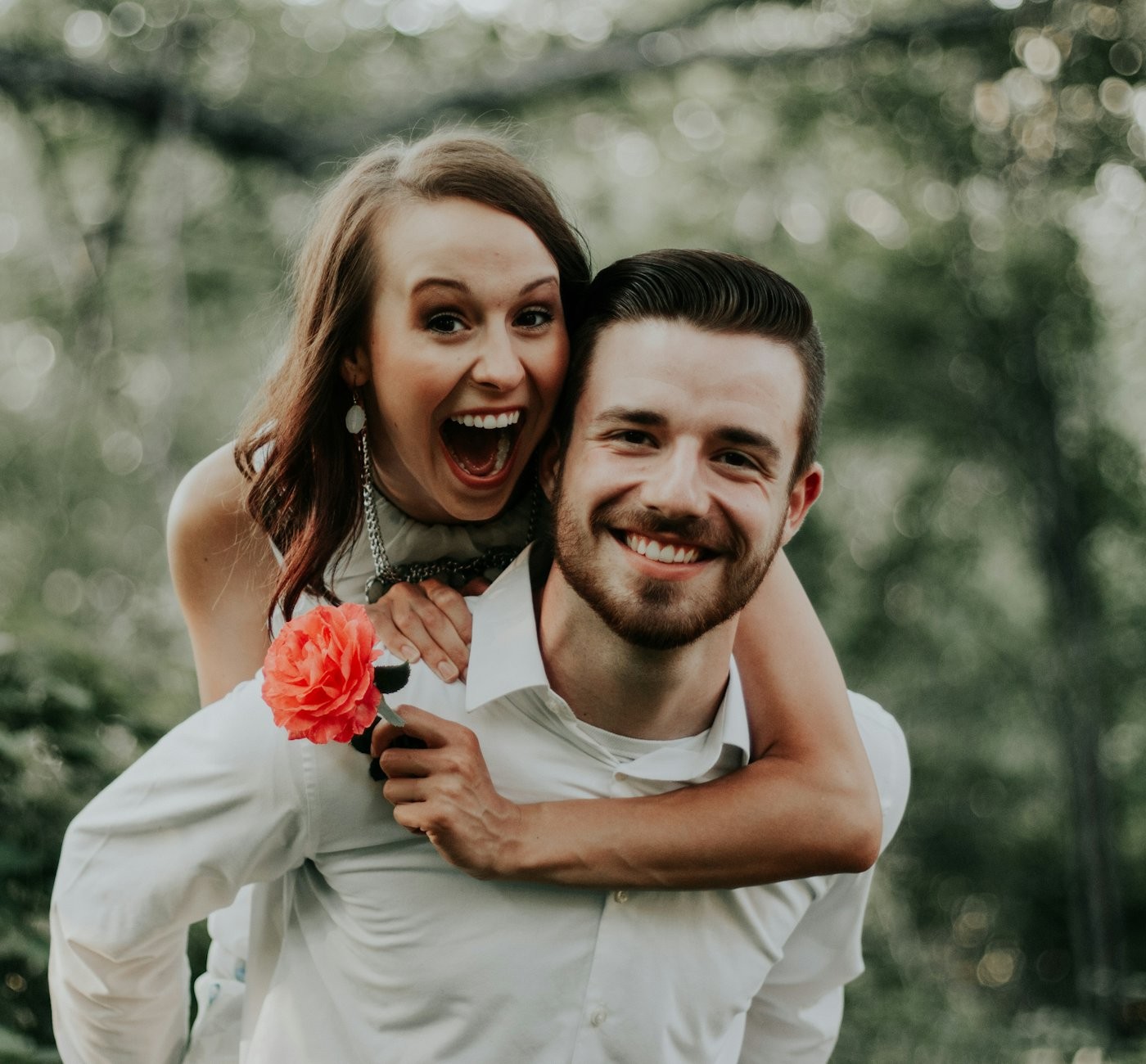 A couple laughing together outdoors on a sunny day